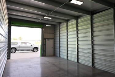 view from inside drive-up storage facility with a regular door entrance closed with garage/roll up door open